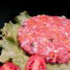 hamburguesa sobre lechuga en fondo negro