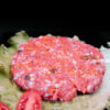 hamburguesa sobre lechuga en fondo negro